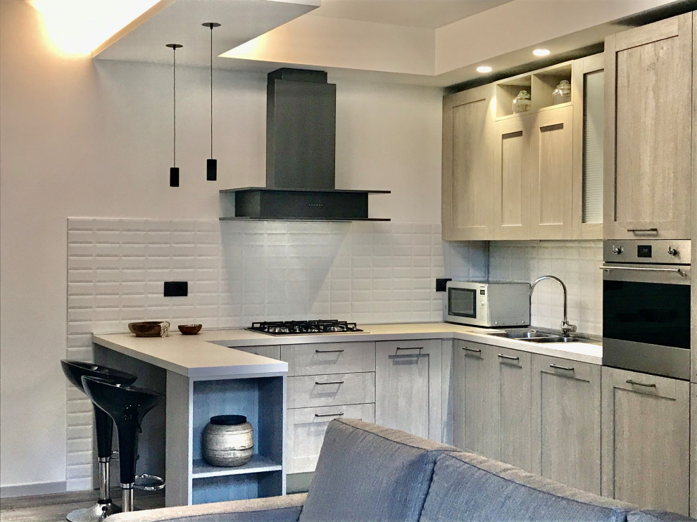 Inspiration for a medium sized industrial u-shaped open plan kitchen in Milan with an integrated sink, raised-panel cabinets, distressed cabinets, white splashback, metro tiled splashback, stainless steel appliances, laminate floors, a breakfast bar and grey worktops.