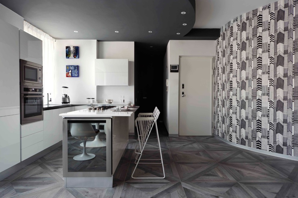 Geräumige Moderne Küche in L-Form mit flächenbündigen Schrankfronten, weißen Schränken, Küchengeräten aus Edelstahl, gebeiztem Holzboden, Kücheninsel und Tapete in Turin