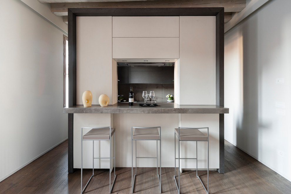 Ispirazione per una piccola cucina lineare contemporanea con ante bianche, parquet scuro, pavimento marrone, ante lisce, paraspruzzi grigio e top grigio