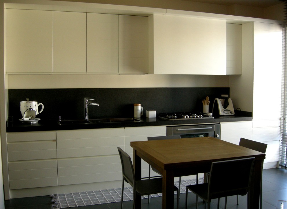 Zweizeilige Moderne Wohnküche mit hellen Holzschränken, Marmor-Arbeitsplatte und Küchengeräten aus Edelstahl in Catania-Palermo