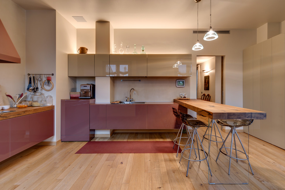 На фото: кухня среднего размера в современном стиле с плоскими фасадами, бежевым фартуком, светлым паркетным полом, полуостровом, бежевыми фасадами и бежевым полом
