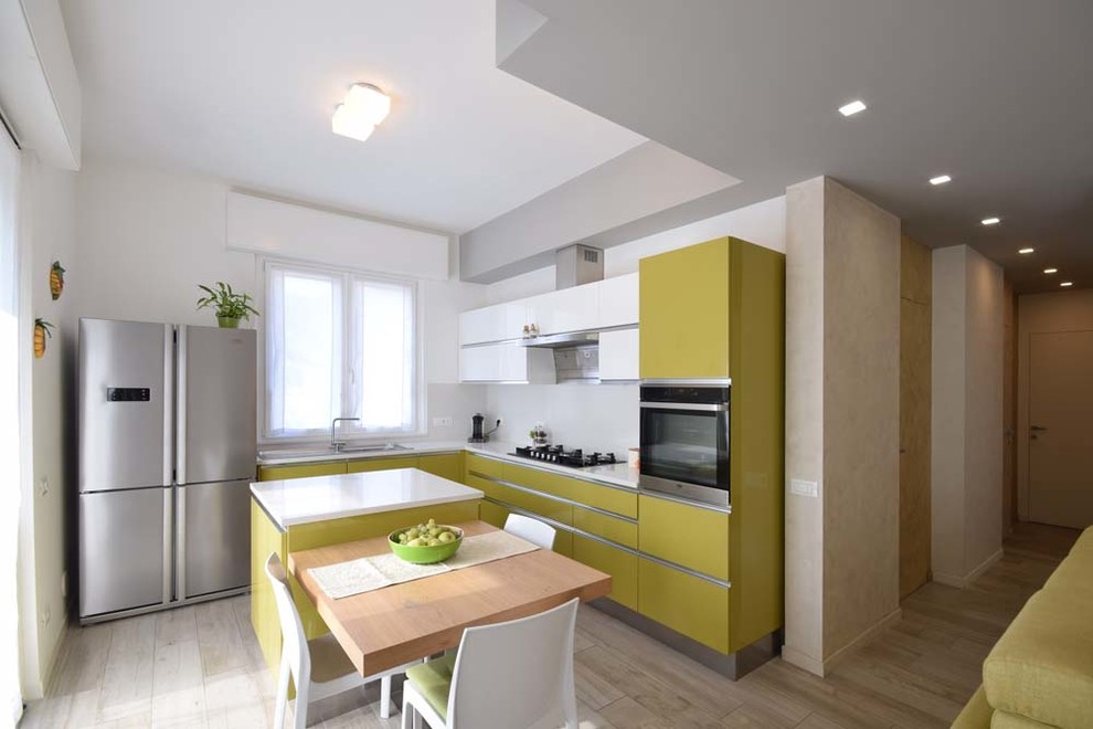 Foto di una cucina design con ante lisce, ante verdi, elettrodomestici in acciaio inossidabile, top bianco, lavello a vasca singola e paraspruzzi bianco