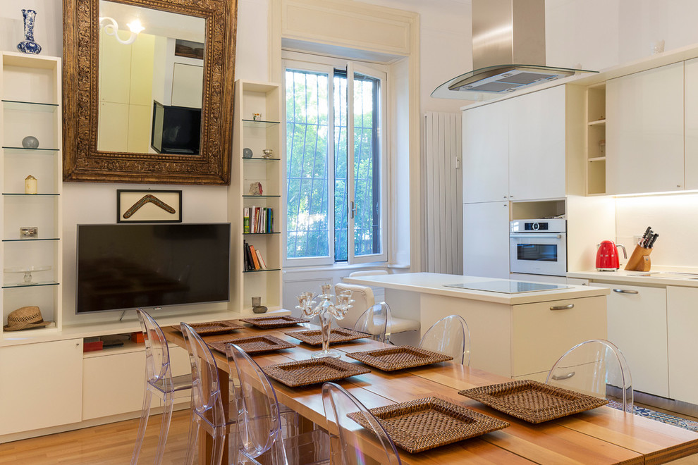 Diseño de cocina lineal de estilo zen de tamaño medio abierta con armarios con paneles lisos, puertas de armario blancas, electrodomésticos blancos y una isla