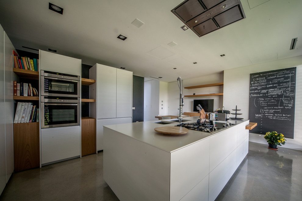 Idéer för att renovera ett mycket stort funkis kök, med en dubbel diskho, släta luckor, vita skåp, rostfria vitvaror, betonggolv och en köksö