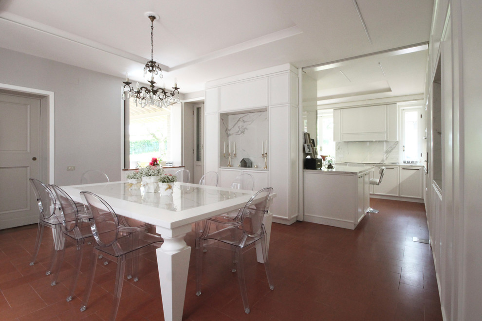 На фото: огромная кухня-столовая в классическом стиле с полом из керамической плитки и красным полом с
