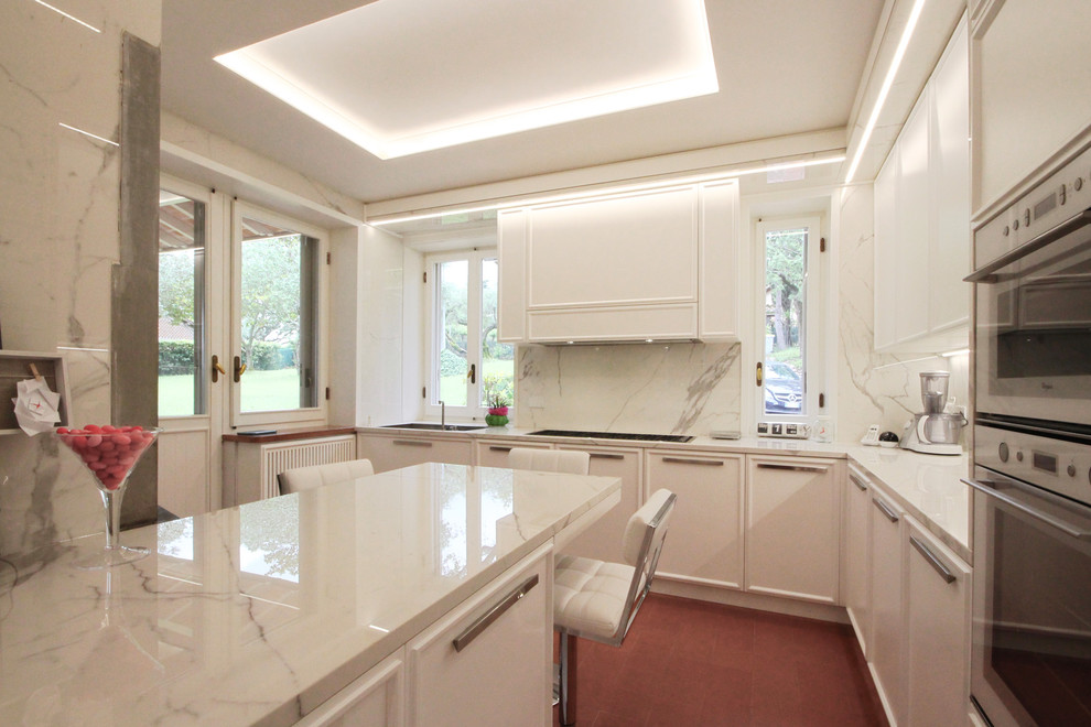 Design ideas for an expansive classic kitchen/diner in Milan with recessed-panel cabinets, marble worktops, white appliances, ceramic flooring, an island, red floors and white worktops.