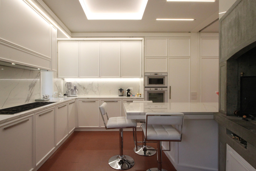 ミラノにあるラグジュアリーな巨大なトラディショナルスタイルのおしゃれなキッチン (落し込みパネル扉のキャビネット、大理石カウンター、白い調理設備、セラミックタイルの床、赤い床、白いキッチンカウンター) の写真
