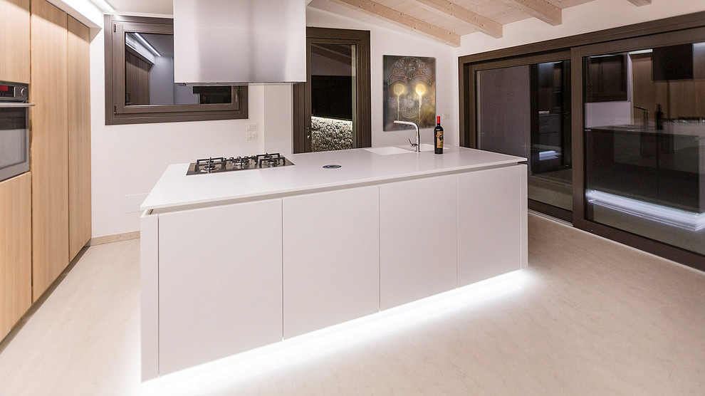 Immagine di una cucina minimalista chiusa e di medie dimensioni con lavello integrato, ante lisce, ante in legno chiaro, top in quarzo composito, elettrodomestici in acciaio inossidabile, pavimento in marmo e pavimento grigio