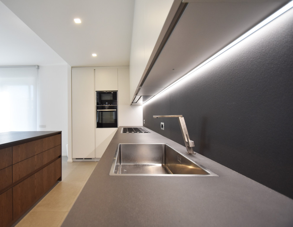 Photo of a medium sized contemporary l-shaped kitchen/diner in Other with a single-bowl sink, white cabinets, quartz worktops, grey splashback, stone slab splashback, stainless steel appliances, porcelain flooring, an island, beige floors and grey worktops.
