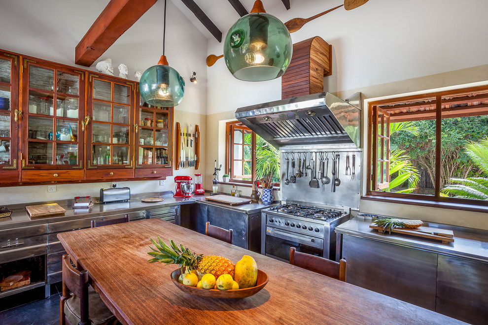 Bild på ett stort tropiskt kök, med skåp i rostfritt stål, bänkskiva i rostfritt stål, rostfria vitvaror och släta luckor