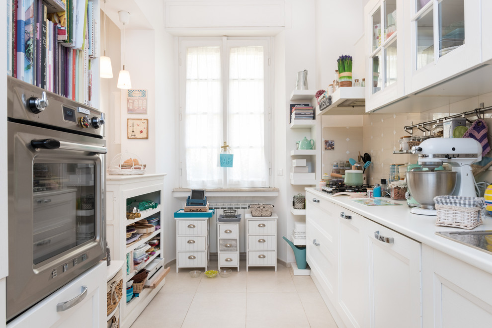 Zweizeilige, Kleine Shabby-Look Küche mit profilierten Schrankfronten, weißen Schränken, Küchenrückwand in Beige, Rückwand aus Keramikfliesen und Küchengeräten aus Edelstahl in Rom