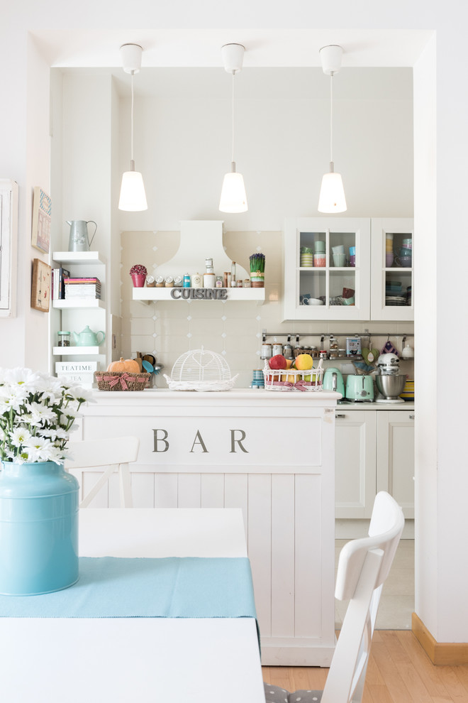 Inspiration for a shabby-chic style kitchen remodel in Rome with glass-front cabinets, white cabinets and an island