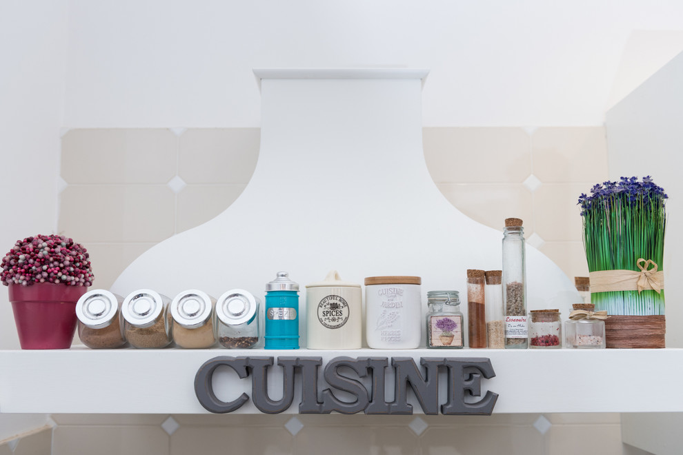 Immagine di un cucina con isola centrale shabby-chic style con ante di vetro e ante bianche