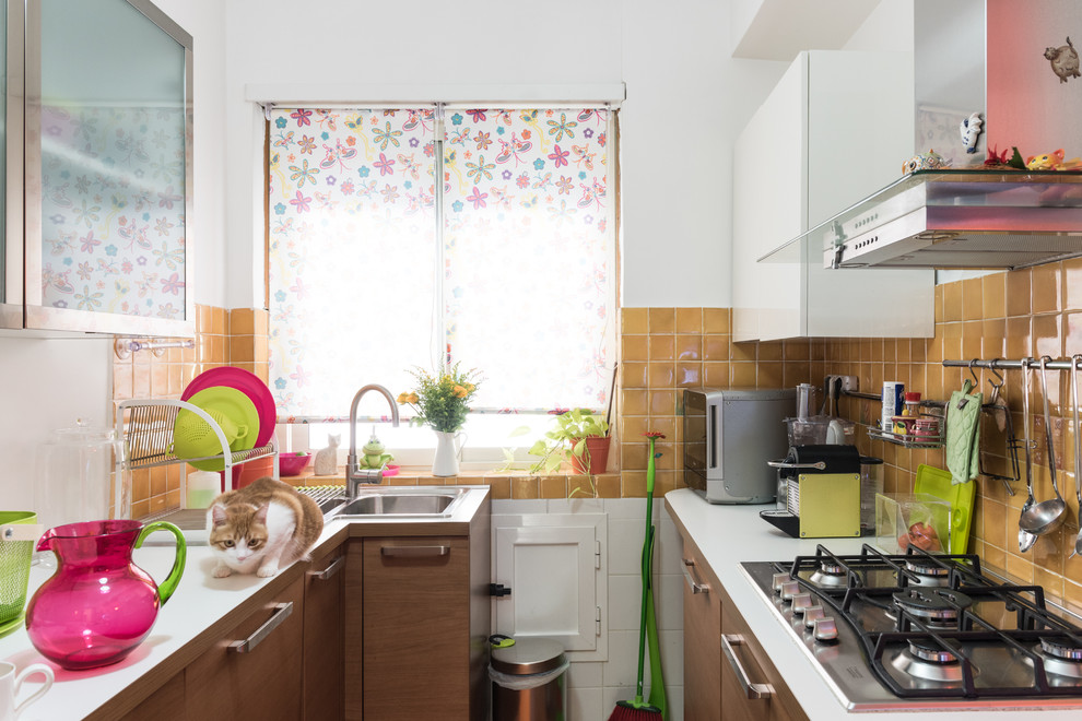 Foto di una piccola cucina ad U minimal con lavello da incasso, ante lisce, ante in legno chiaro, top in laminato, paraspruzzi giallo e paraspruzzi con piastrelle in ceramica