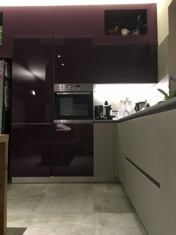 Modern inredning av ett litet grå grått kök, med en integrerad diskho, släta luckor, lila skåp, bänkskiva i kvarts, grått stänkskydd, stänkskydd i porslinskakel, rostfria vitvaror, klinkergolv i porslin, en halv köksö och grått golv