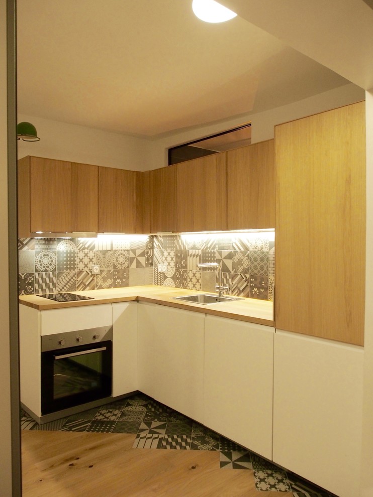Exempel på ett mellanstort modernt kök, med en undermonterad diskho, luckor med profilerade fronter, skåp i ljust trä, träbänkskiva, grått stänkskydd, stänkskydd i keramik, rostfria vitvaror och ljust trägolv