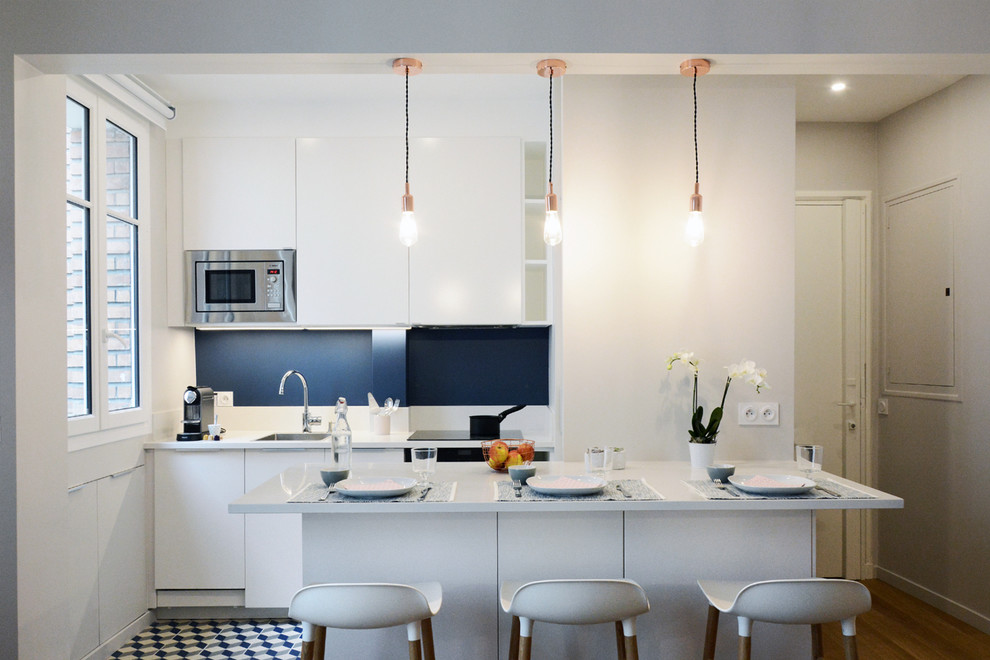 Design ideas for a modern kitchen in Paris with quartz worktops, white splashback and cement flooring.