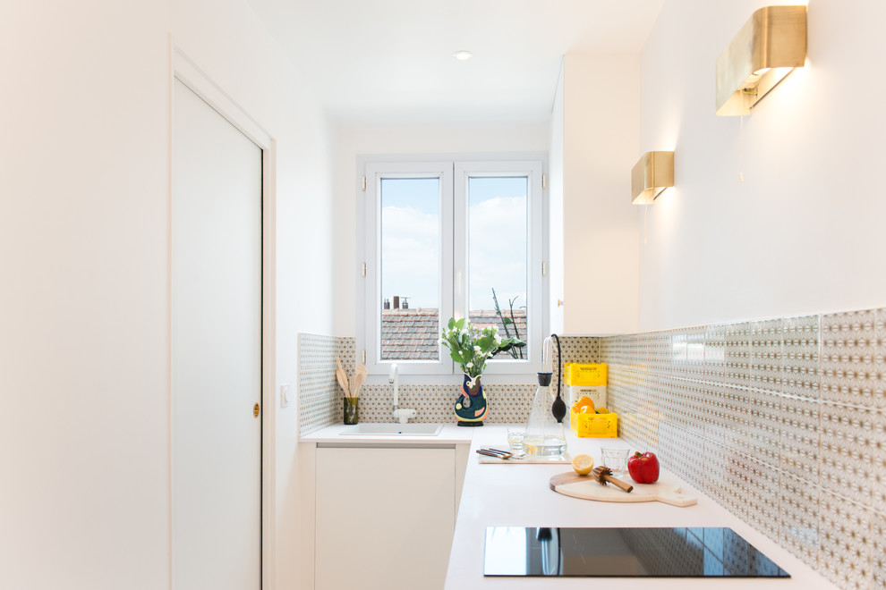 Geschlossene, Kleine Moderne Küche ohne Insel in L-Form mit Einbauwaschbecken, bunter Rückwand und weißen Schränken in Paris