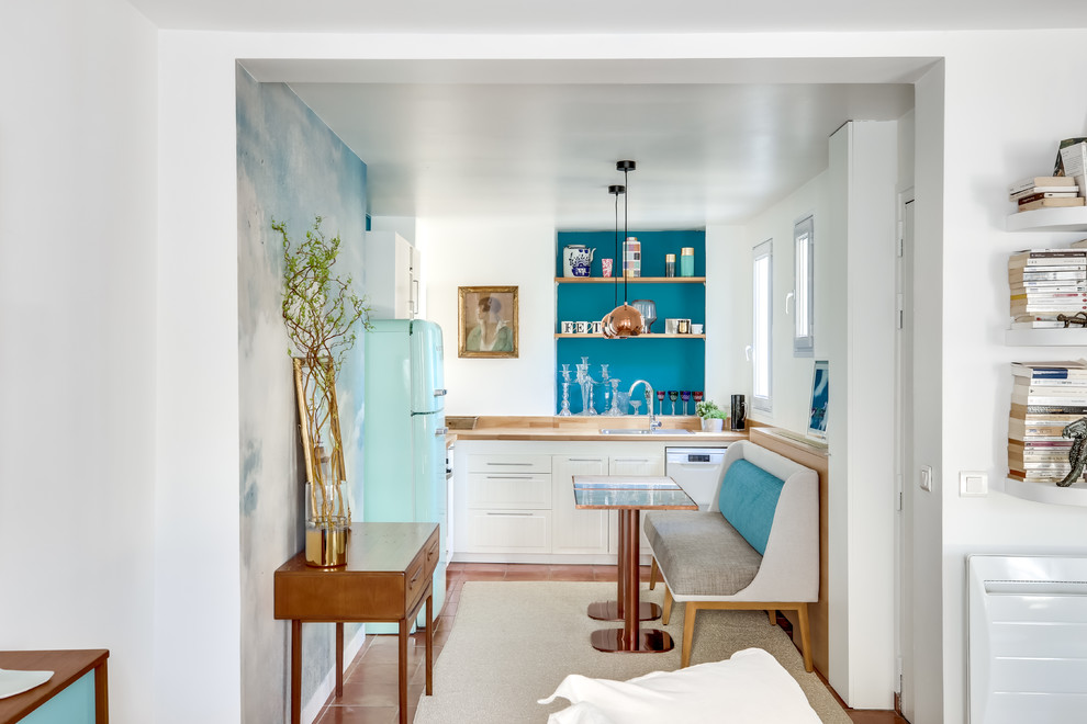 パリにある高級な中くらいなエクレクティックスタイルのおしゃれなキッチン (淡色木目調キャビネット、木材カウンター、カラー調理設備、テラコッタタイルの床、茶色い床) の写真