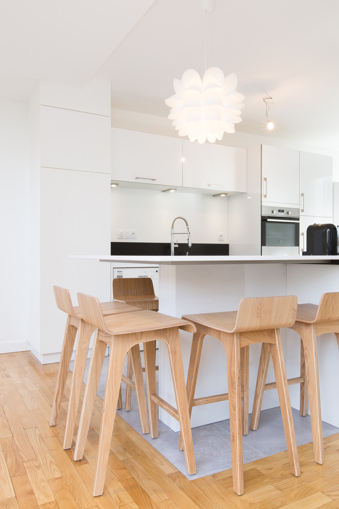 Стильный дизайн: параллельная кухня-гостиная среднего размера в современном стиле с белыми фасадами, техникой под мебельный фасад, полом из керамической плитки и островом - последний тренд