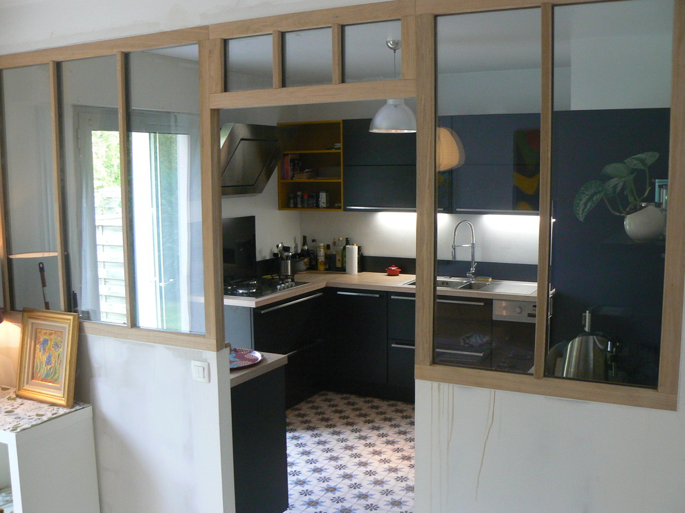 Geschlossene, Kleine Retro Küche in L-Form mit flächenbündigen Schrankfronten, schwarzen Schränken, Laminat-Arbeitsplatte und Zementfliesen für Boden in Rennes