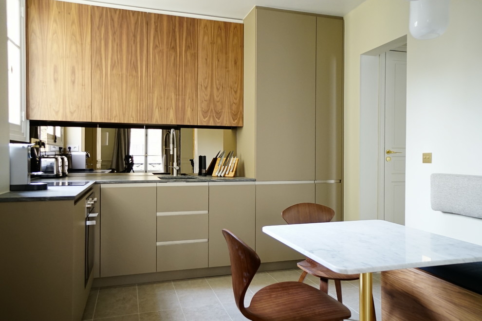 This is an example of a small contemporary l-shaped kitchen/diner in Paris with a submerged sink, flat-panel cabinets, beige cabinets, no island, grey floors and grey worktops.