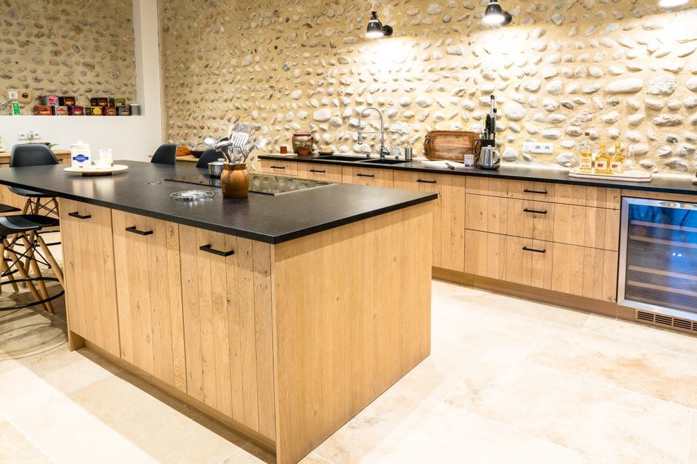 Immagine di una cucina industriale con lavello integrato, ante in legno chiaro, top in granito, elettrodomestici in acciaio inossidabile, pavimento in travertino e pavimento beige