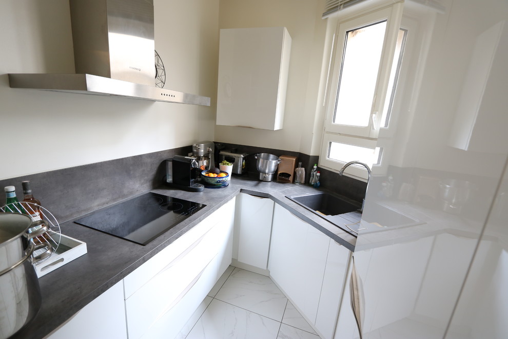 Small modern u-shaped open plan kitchen in Paris with an integrated sink, beaded cabinets, white cabinets, wood worktops, grey splashback, ceramic splashback, stainless steel appliances, ceramic flooring, white floors and grey worktops.