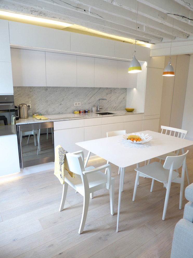 Medium sized contemporary grey and white single-wall open plan kitchen in Paris with flat-panel cabinets, white cabinets, white splashback, stone slab splashback, light hardwood flooring and no island.