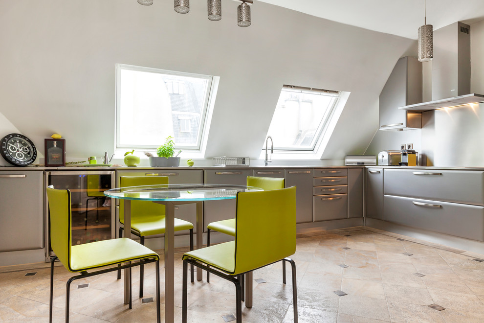 Große Moderne Wohnküche in L-Form mit flächenbündigen Schrankfronten, grauen Schränken und Edelstahl-Arbeitsplatte in Paris