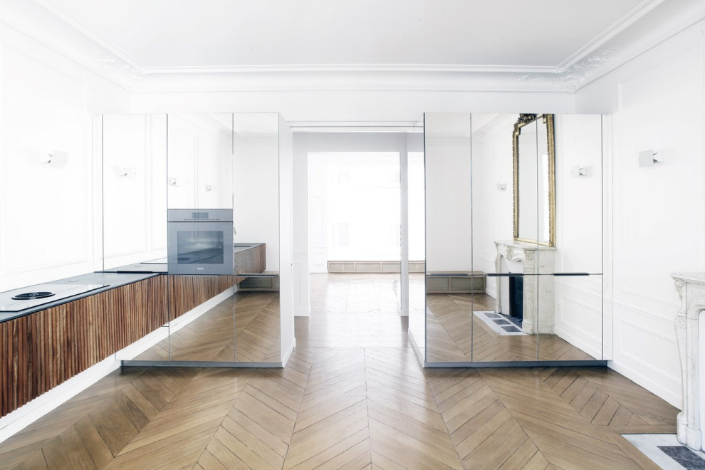 Offene, Zweizeilige, Große Moderne Küche mit integriertem Waschbecken, Glasfronten, Laminat, braunem Boden und grauer Arbeitsplatte in Paris