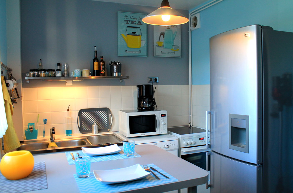Foto på ett avskilt, litet skandinaviskt linjärt kök, med en dubbel diskho, vitt stänkskydd och en köksö