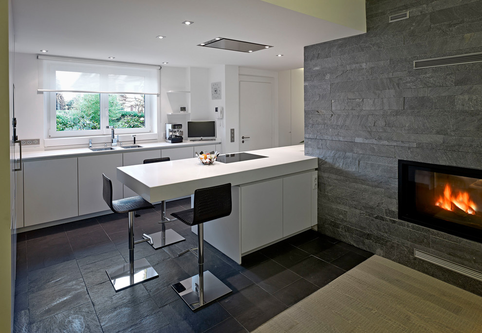 Photo of a modern u-shaped kitchen/diner in Strasbourg with an integrated sink, an island and grey floors.