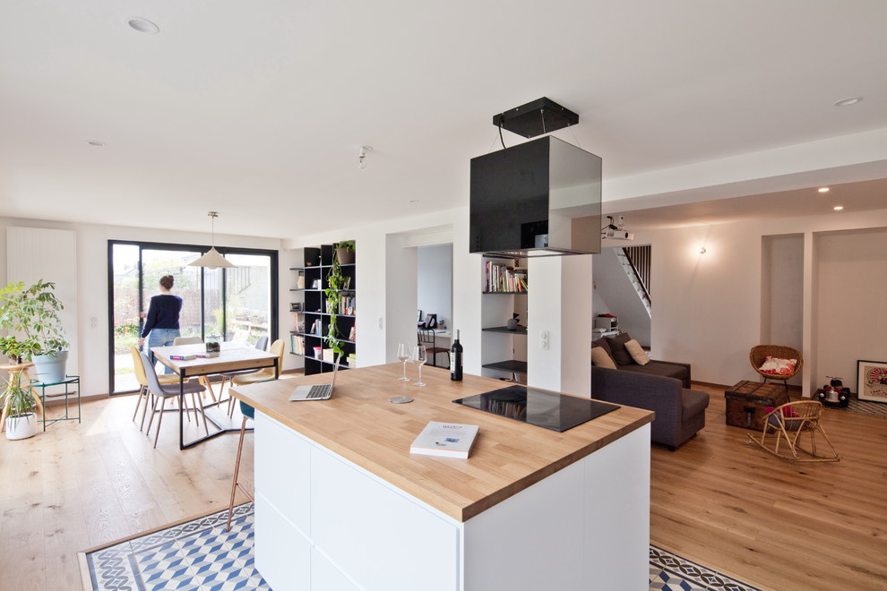 Mittelgroße Moderne Küche mit flächenbündigen Schrankfronten, weißen Schränken, Arbeitsplatte aus Holz, Keramikboden, Kücheninsel und blauem Boden in Nantes