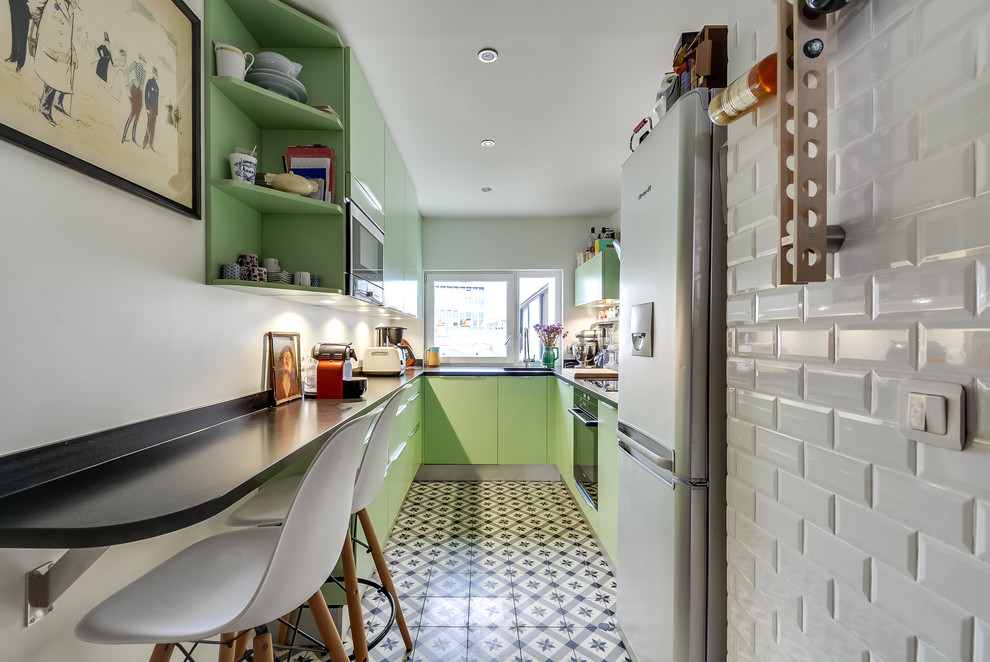 Example of a mid-sized trendy u-shaped ceramic tile eat-in kitchen design in Paris with an integrated sink, flat-panel cabinets, green cabinets, granite countertops, white backsplash, subway tile backsplash and no island