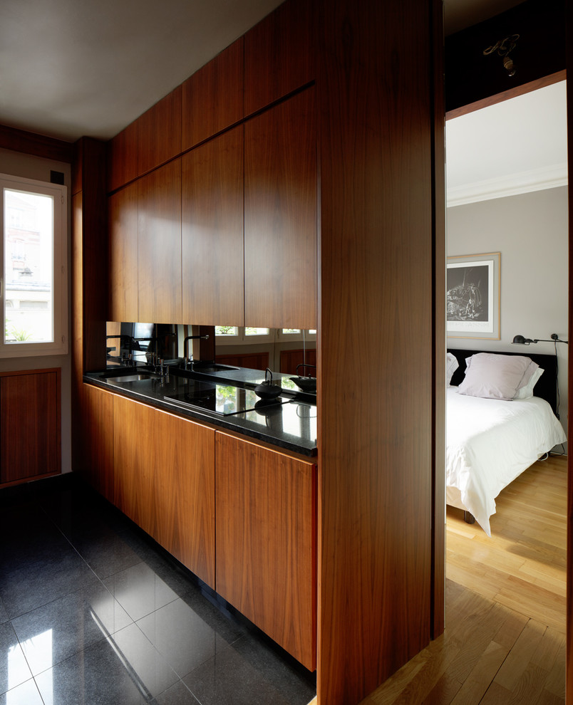 Imagen de cocina lineal contemporánea pequeña abierta con fregadero bajoencimera, puertas de armario de madera en tonos medios y salpicadero con efecto espejo