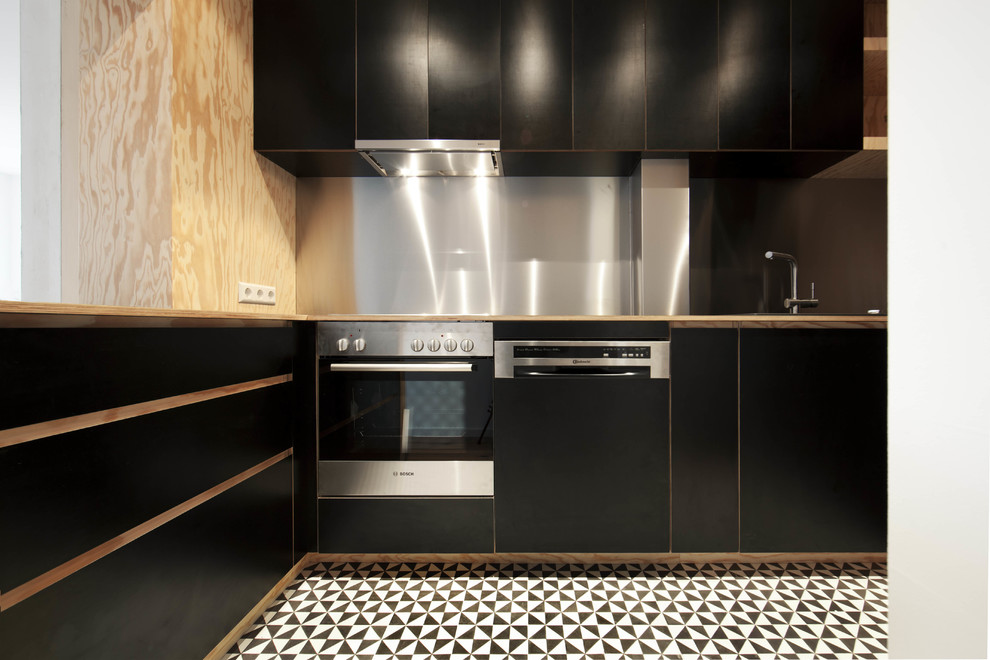Foto på ett mellanstort funkis l-kök, med släta luckor, träbänkskiva, stänkskydd med metallisk yta, rostfria vitvaror och svarta skåp