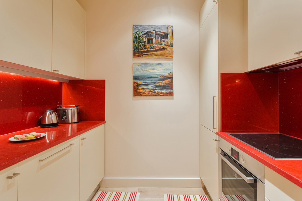 パリにある高級な中くらいなコンテンポラリースタイルのおしゃれなキッチン (インセット扉のキャビネット、ベージュのキャビネット、クオーツストーンカウンター、赤いキッチンパネル、ライムストーンのキッチンパネル、シルバーの調理設備、淡色無垢フローリング、アイランドなし、茶色い床、赤いキッチンカウンター) の写真