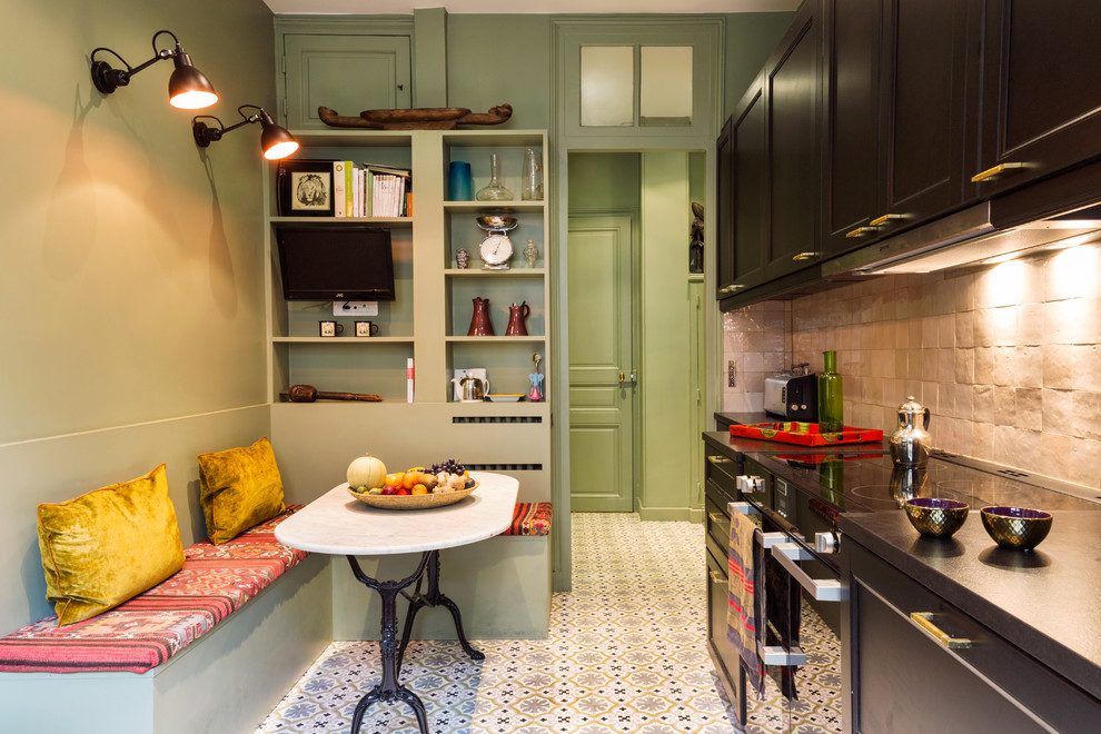 Inspiration for a large industrial single-wall cement tile floor and pink floor eat-in kitchen remodel in Paris with recessed-panel cabinets, black cabinets, beige backsplash, mosaic tile backsplash, black appliances, no island, black countertops and an undermount sink
