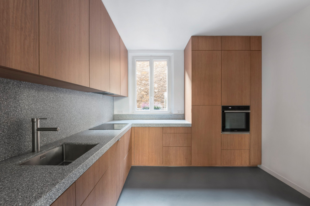 Inspiration for a contemporary enclosed kitchen in Paris with an integrated sink, beaded cabinets, red cabinets, terrazzo worktops, grey splashback, stainless steel appliances, concrete flooring, grey floors and grey worktops.