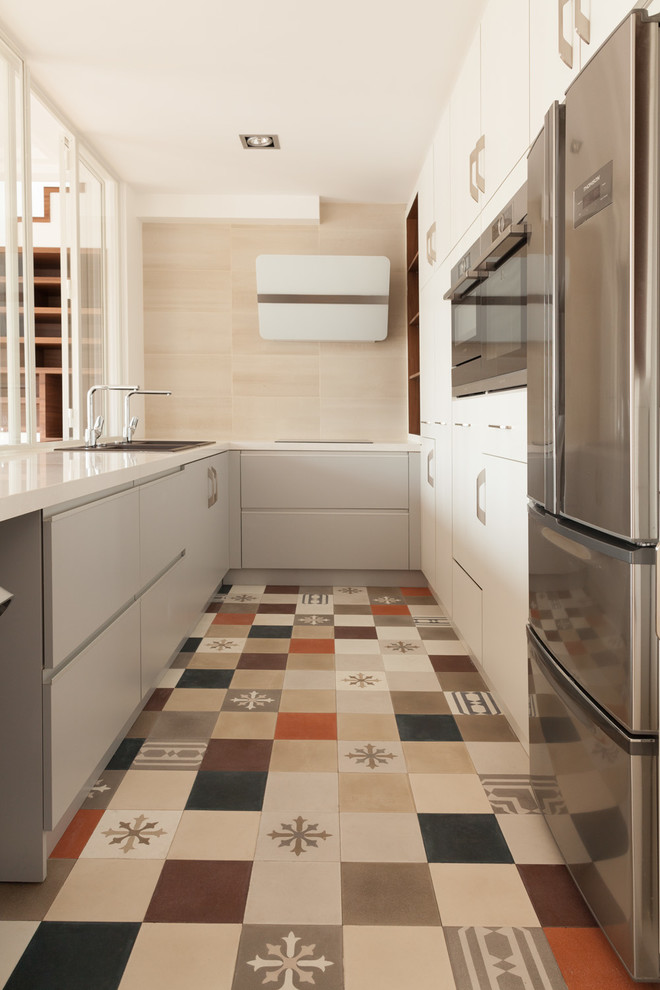 Foto di una cucina minimal di medie dimensioni con lavello sottopiano, ante bianche, elettrodomestici in acciaio inossidabile e ante lisce