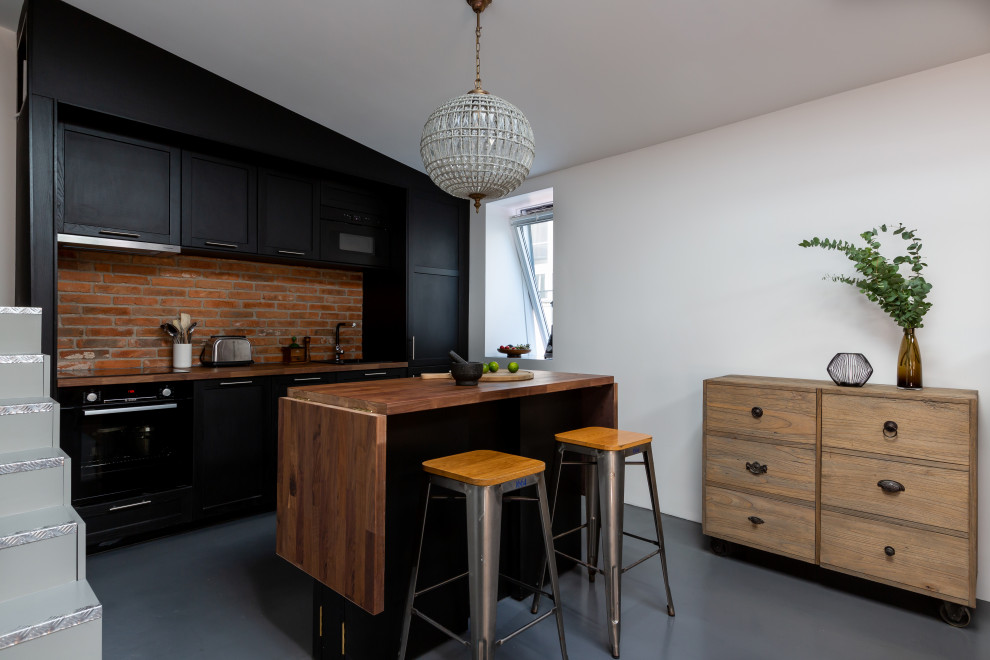 Exempel på ett stort industriellt brun linjärt brunt kök med öppen planlösning, med en undermonterad diskho, skåp i shakerstil, svarta skåp, träbänkskiva, stänkskydd i tegel, integrerade vitvaror, betonggolv, en köksö, grått golv och rött stänkskydd