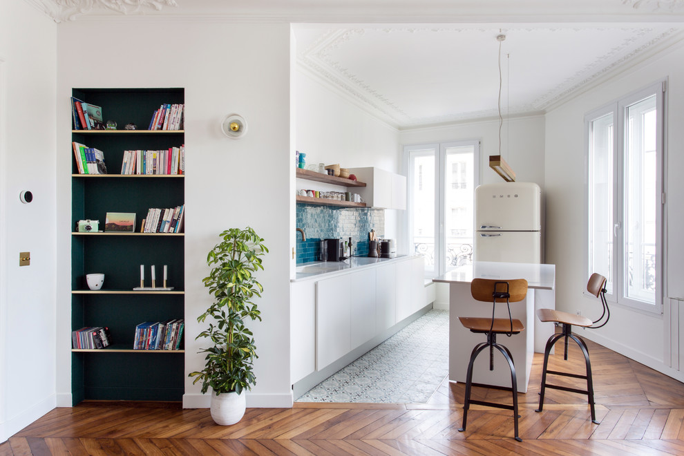 パリにある高級な中くらいなミッドセンチュリースタイルのおしゃれなキッチン (大理石カウンター、青いキッチンパネル、セラミックタイルのキッチンパネル、セメントタイルの床、青い床、白いキッチンカウンター) の写真