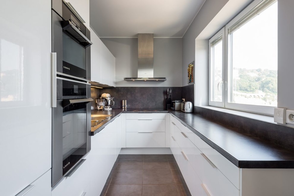 Exemple d'une cuisine grise et blanche tendance en L de taille moyenne et fermée avec un placard à porte plane, des portes de placard blanches et un électroménager en acier inoxydable.