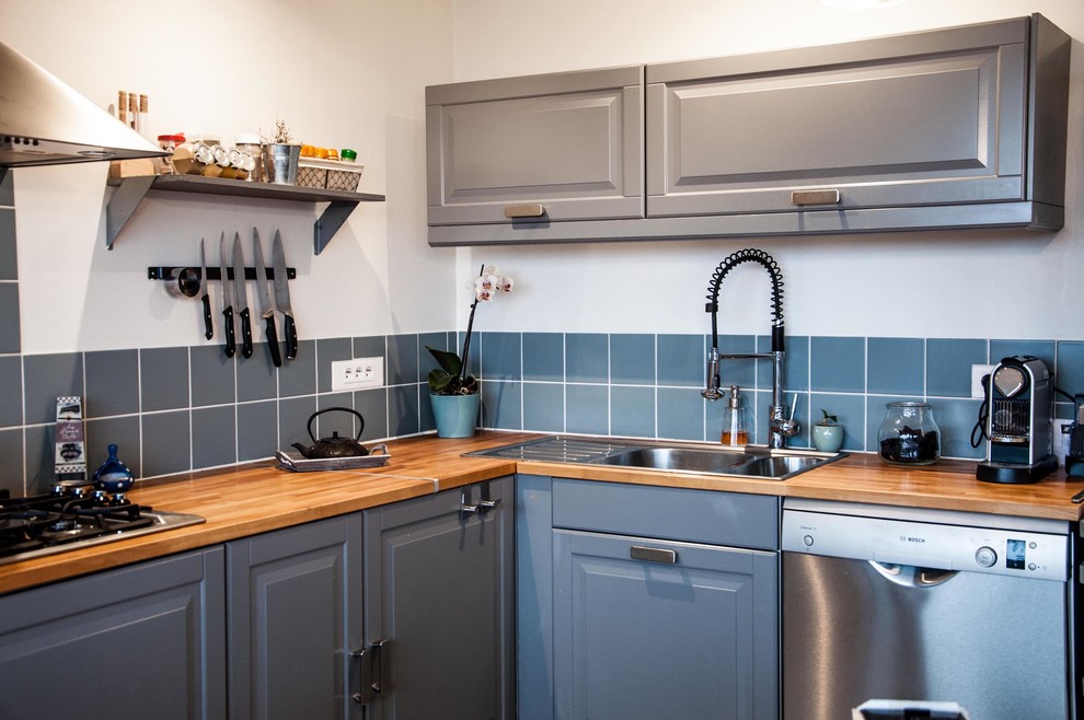 Medium sized classic l-shaped enclosed kitchen in Paris with a double-bowl sink, raised-panel cabinets, grey cabinets, wood worktops, blue splashback, stainless steel appliances and no island.