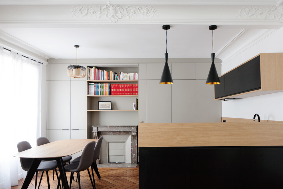 Photo of a medium sized contemporary l-shaped open plan kitchen in Paris with a submerged sink, flat-panel cabinets, black cabinets, wood worktops, beige splashback, wood splashback, medium hardwood flooring, no island and brown floors.