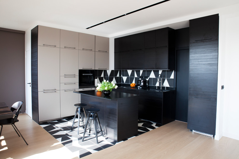 Exempel på ett mellanstort skandinaviskt svart svart kök, med klinkergolv i keramik, svart golv, en undermonterad diskho, luckor med profilerade fronter, svarta skåp, bänkskiva i kvarts, flerfärgad stänkskydd, stänkskydd i porslinskakel, svarta vitvaror och en köksö