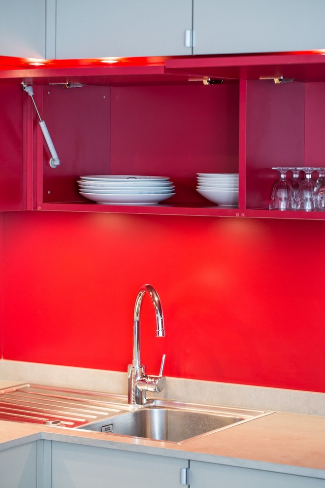 Kleine Moderne Wohnküche in L-Form mit Waschbecken, Kassettenfronten, Granit-Arbeitsplatte und Küchenrückwand in Rot in Paris