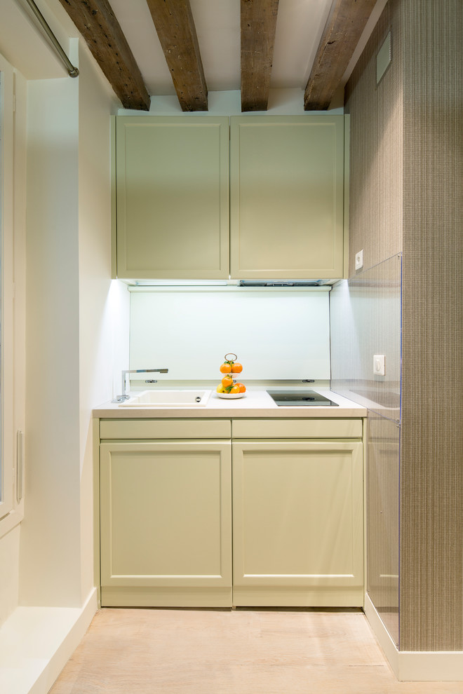 Inredning av ett modernt litet beige linjärt beige kök och matrum, med en integrerad diskho, luckor med profilerade fronter, gröna skåp, laminatbänkskiva, beige stänkskydd, integrerade vitvaror, ljust trägolv och beiget golv