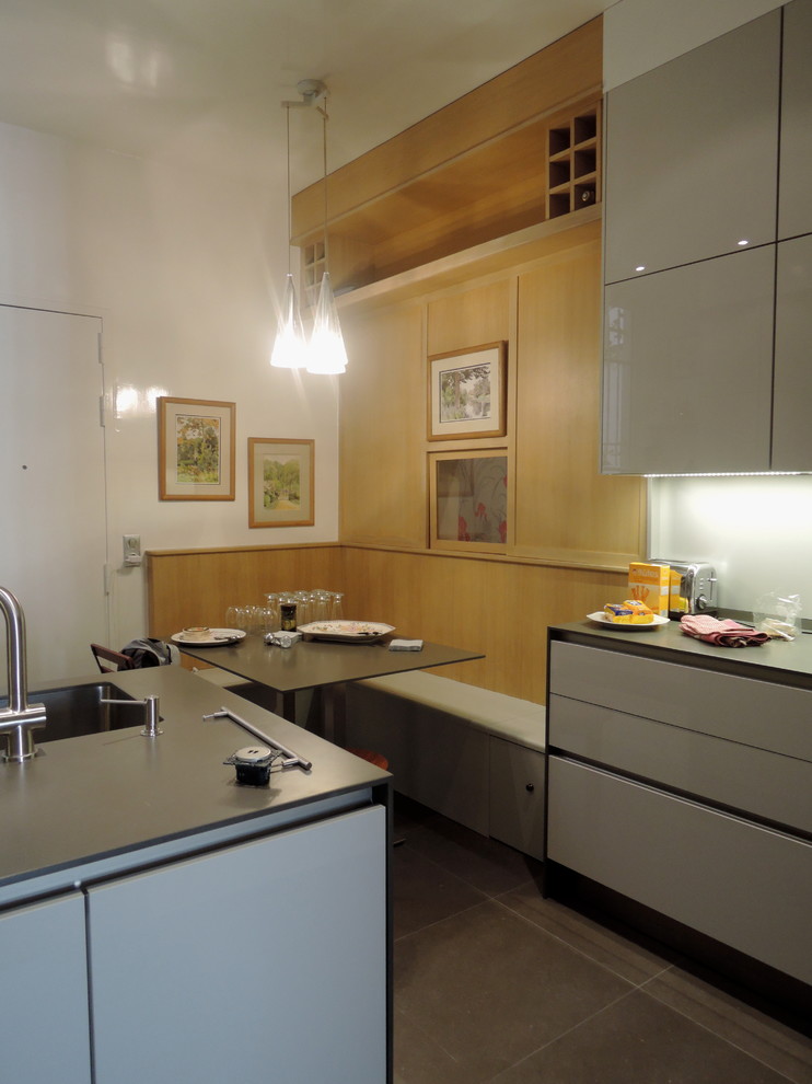 Geschlossene, Einzeilige, Große Moderne Küche mit integriertem Waschbecken, Kassettenfronten, grauen Schränken, Mineralwerkstoff-Arbeitsplatte und Kücheninsel in Paris